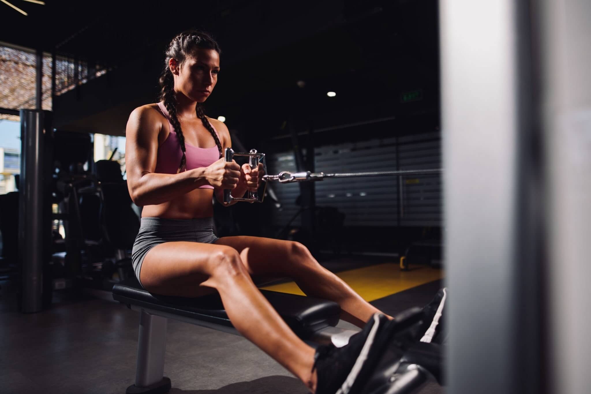 Chica en el gimnasio haciendo remo en máquina