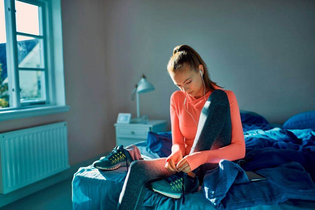 chica-en-la-cama-preparandose-para-ir-a-correr